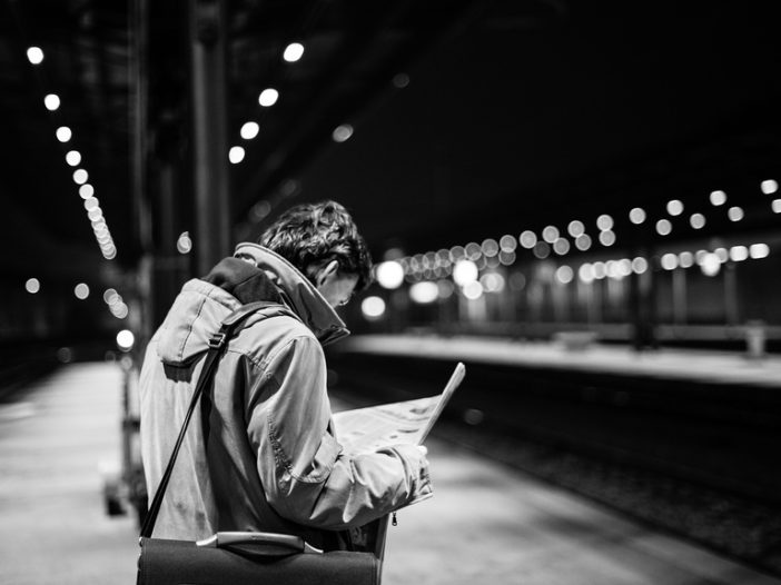 person at a train station at night