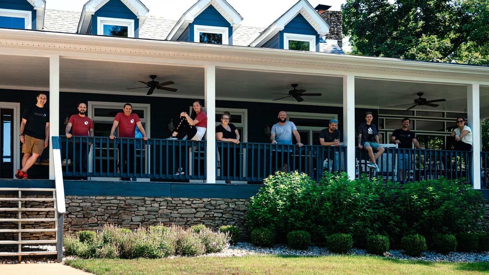 Multiple people standing on a porch facing the camera